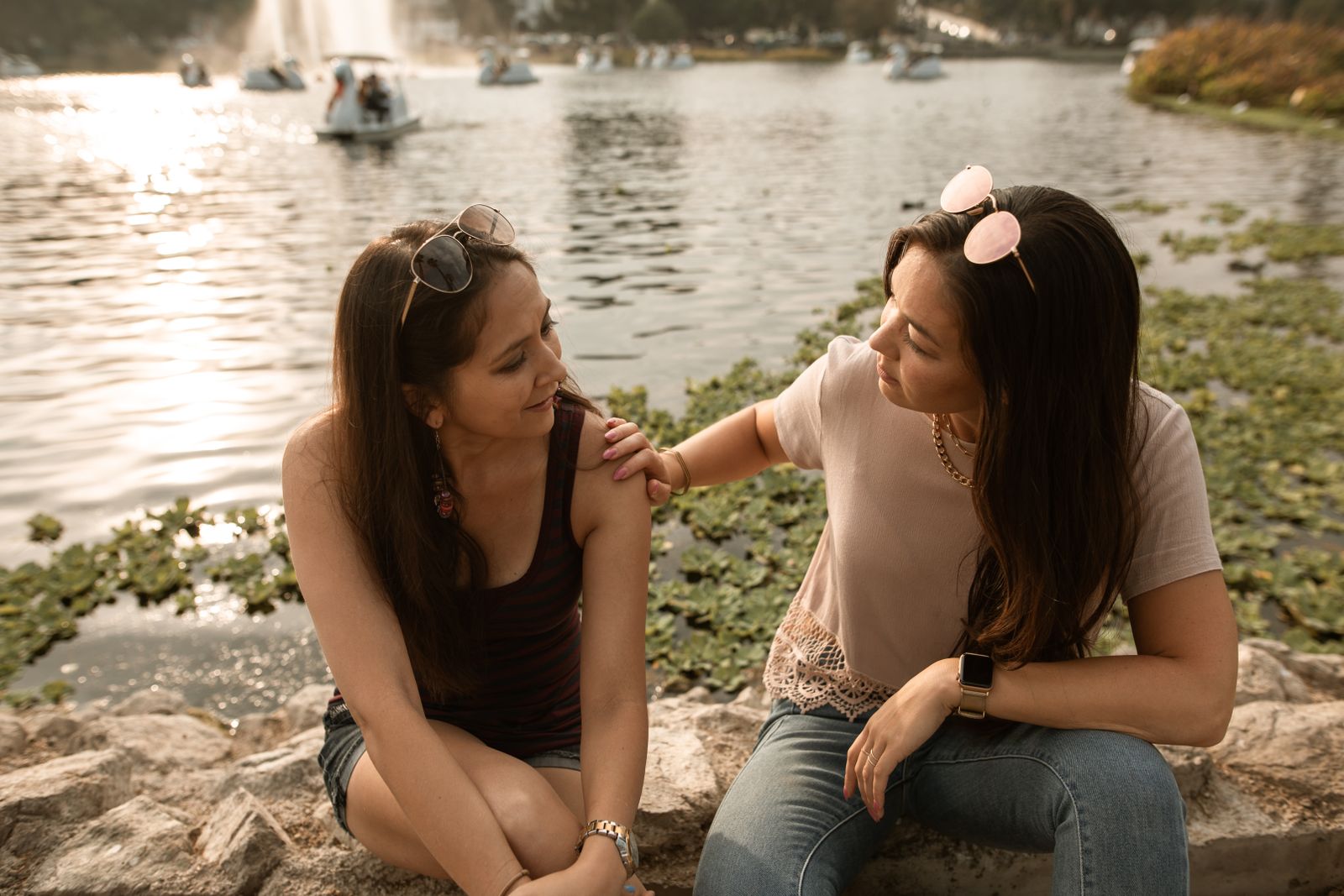 Two friends having a warm, heart-to-heart conversation by a lake